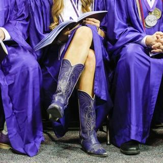 一名TCU毕业生穿着紫色牛仔靴搭配毕业礼服