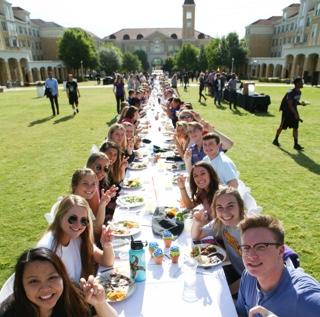 学生们一起用餐，餐桌延伸到TCU校园公共区域的长度